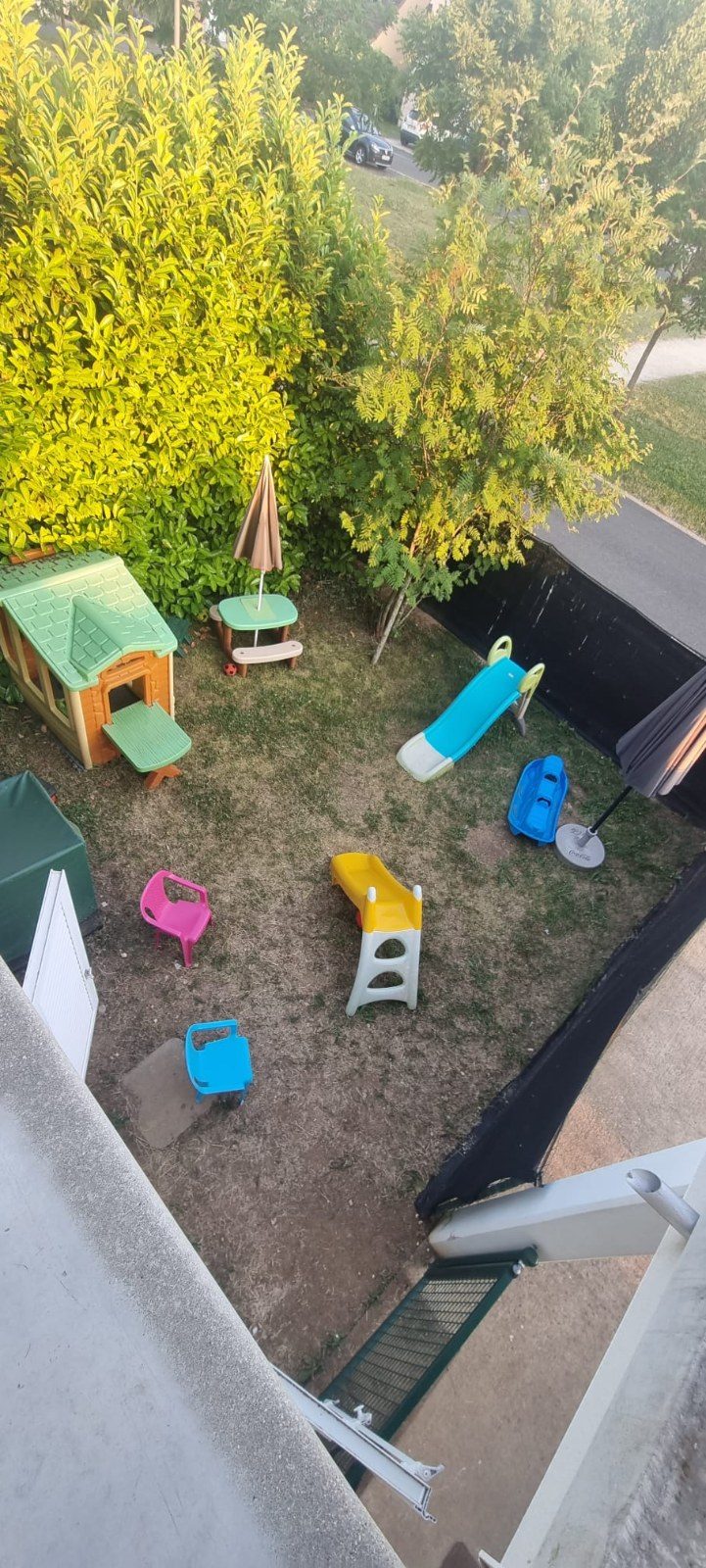 Jardin clos et sécurisé de l'assistante maternelle à Angerville : cabane, toboggans, table de pique-nique et petites chaises pour les tout-petits